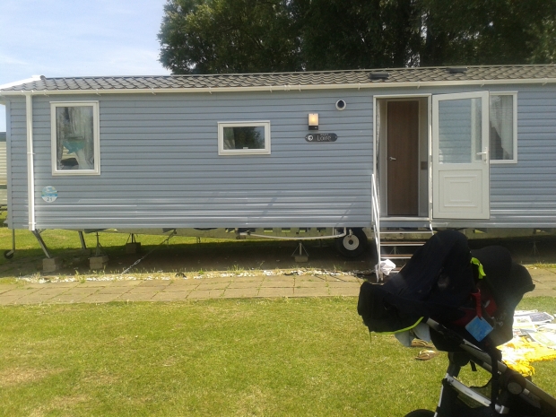 Exterior of our mobile home, Mr Baby parked up under his snooze shade after a walk